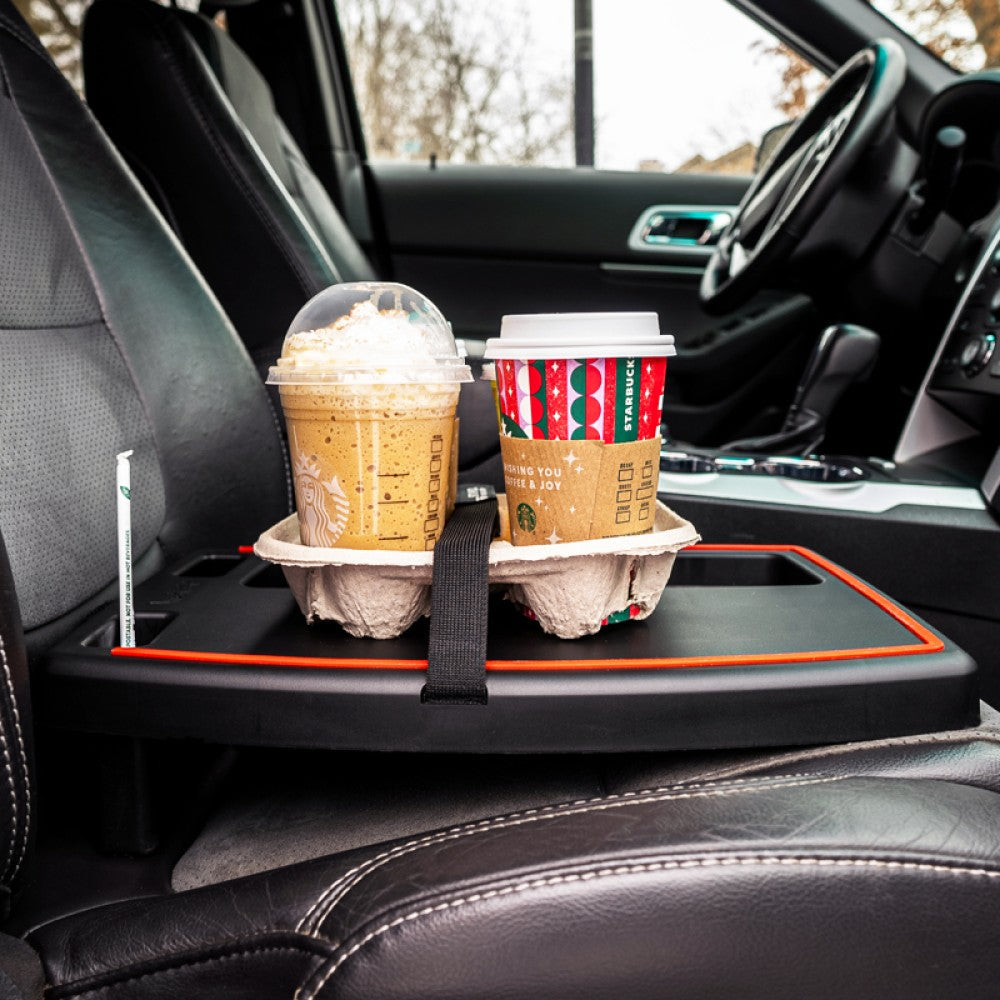 Stupid Car Tray on a passenger seat holding a four pack of Starbucks coffees